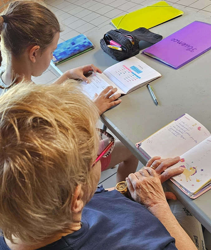 Une dame et un enfant qui font les devoirs ensemble